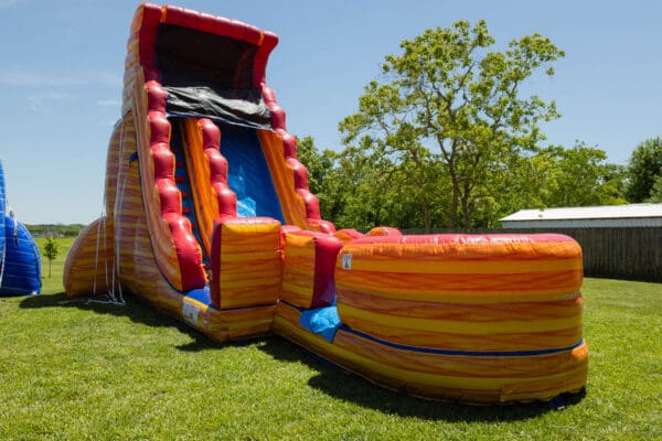 A large inflatable slide and pool in the grass.